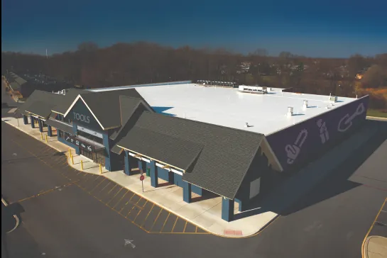 Aerial view of a commercial building with a white coated roof