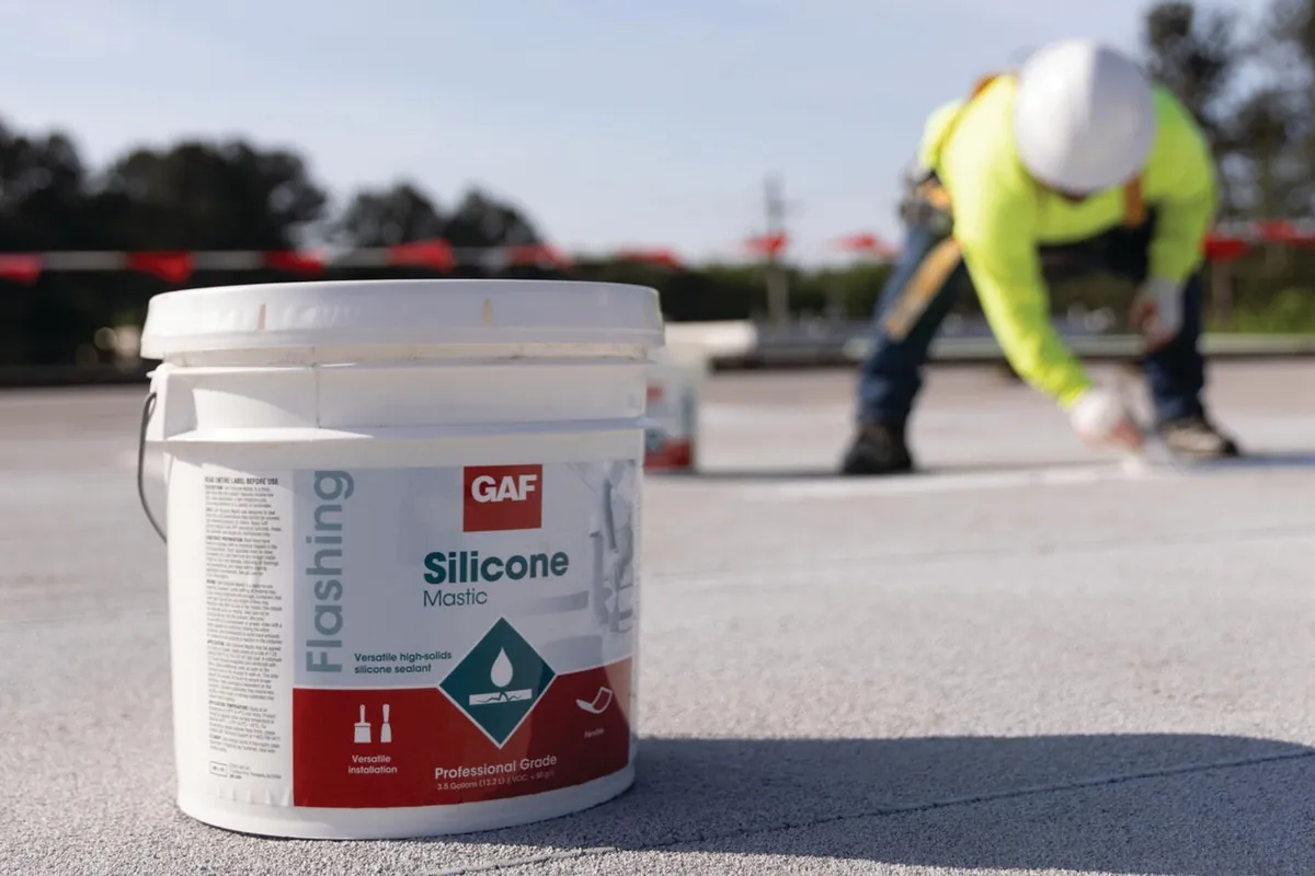 Silicone mastic being brushed onto a roof seam before coating